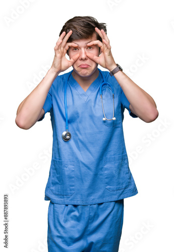 Young doctor wearing medical uniform over isolated background Trying to open eyes with fingers, sleepy and tired for morning fatigue