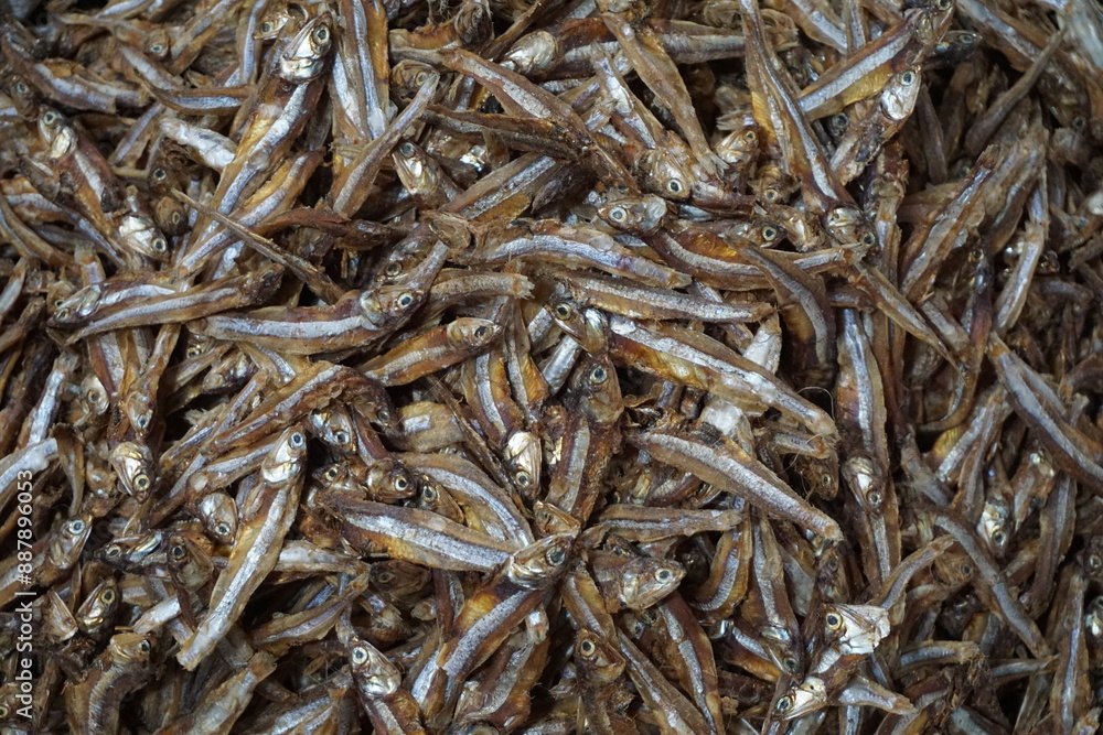 A pile of dried anchovies displayed in a fish market, Little dried fish in an Asian fish market, Fresh dried sardines and anchovies being displayed for selling at a seafood market A pile of dried anchovies displayed in a fish market, Little dried fish in an Asian fish market, Fresh dried sardines and anchovies being displayed for selling at a seafood market