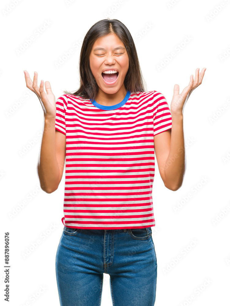Young asian woman over isolated background celebrating mad and crazy for success with arms raised and closed eyes screaming excited. Winner concept Young asian woman over isolated background celebrating mad and crazy for success with arms raised and closed eyes screaming excited. Winner concept