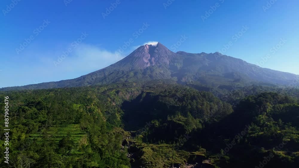 Aerial drone flight video of a panoramic view of Mount Merapi with beautiful views on a summer morning. 4k landscape of an active volcano in detail with a green forest in front of it Aerial drone flight video of a panoramic view of Mount Merapi with beautiful views on a summer morning. 4k landscape of an active volcano in detail with a green forest in front of it