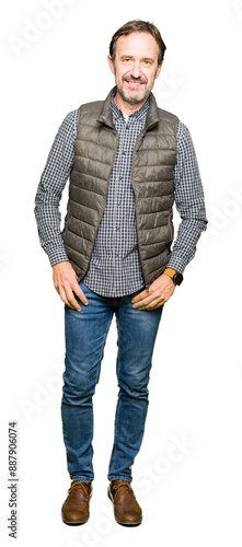 Middle age handsome man wearing winter vest Relaxed with serious expression on face. Simple and natural looking at the camera.