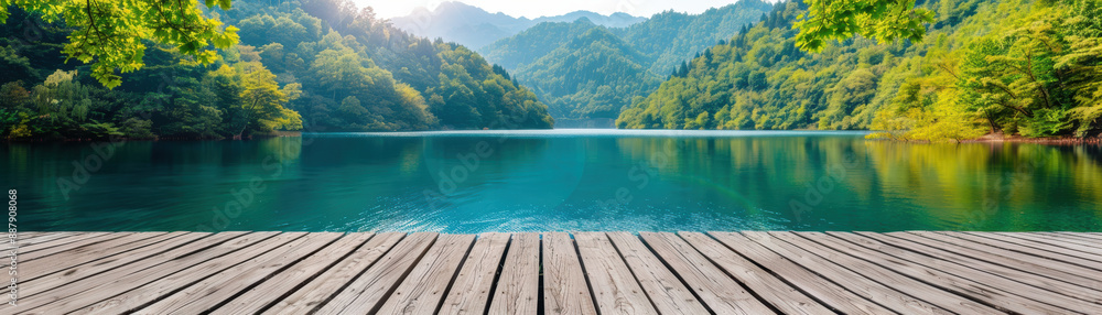 Peaceful wooden pier overlooking a serene emerald lake surrounded by lush green forests and distant mountains under a clear blue sky. Peaceful wooden pier overlooking a serene emerald lake surrounded by lush green forests and distant mountains under a clear blue sky.