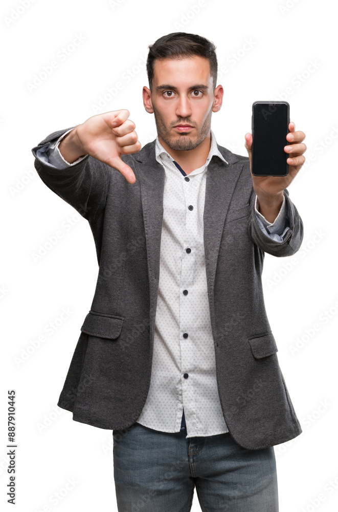 Handsome young man using smartphone with angry face, negative sign showing dislike with thumbs down, rejection concept Handsome young man using smartphone with angry face, negative sign showing dislike with thumbs down, rejection concept