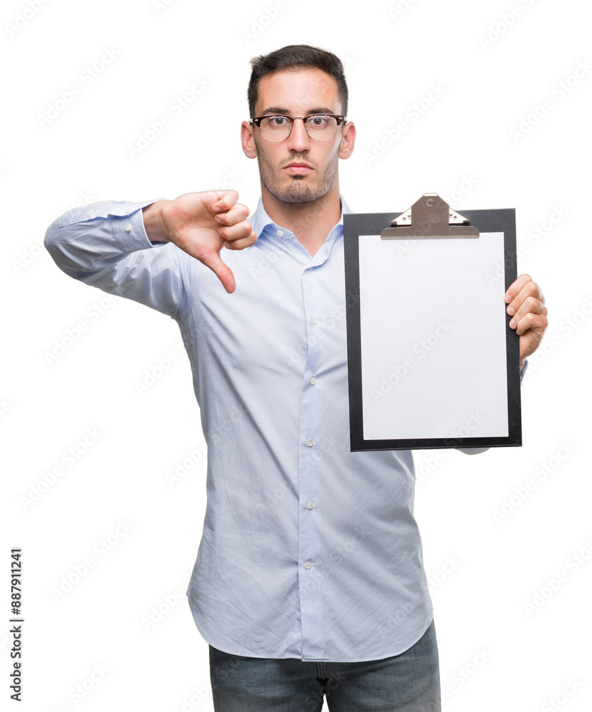 Handsome young business man showing a clipboard with angry face, negative sign showing dislike with thumbs down, rejection concept Handsome young business man showing a clipboard with angry face, negative sign showing dislike with thumbs down, rejection concept