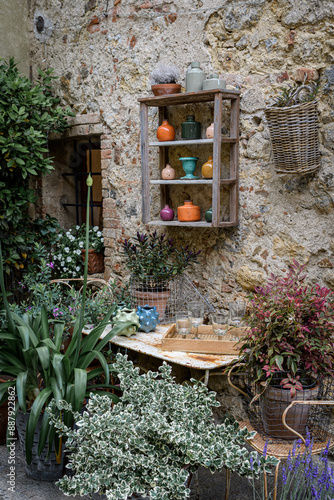 vases on a shelf on a stone wall with plants