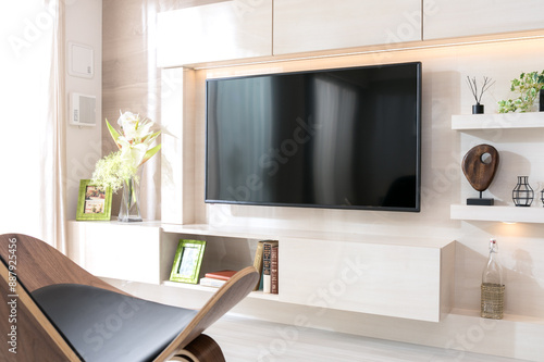 壁掛けテレビのある明るいリビングルーム