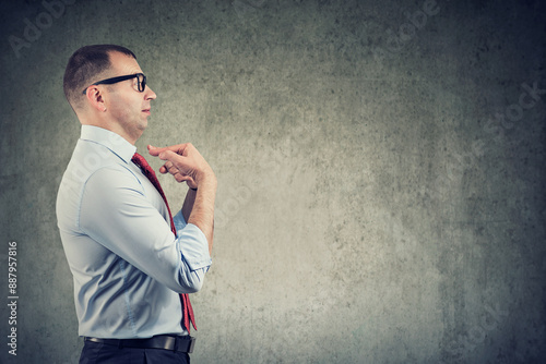 Side profile of a middle aged businessman pointing fingers at himself being in denial