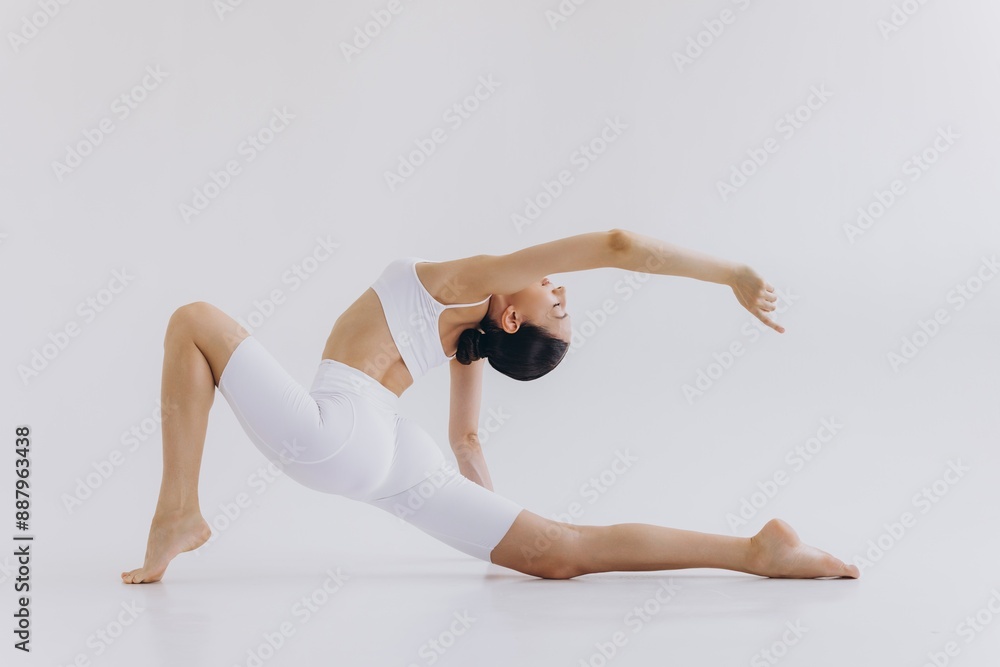 Obraz premium Full length image of sporty young woman with slim body doing yoga practice isolated on white background - concept of healthy life and natural balance between body and mental development