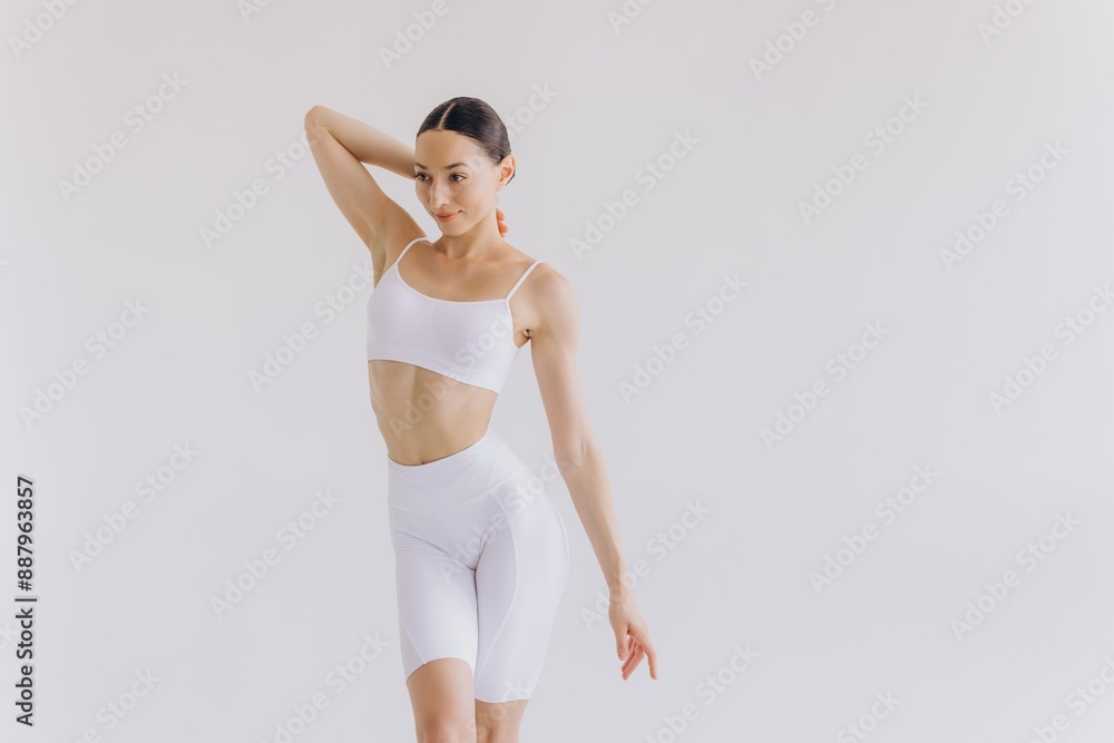 Young slim woman in white sportwear on white background isolated. Muscular slim attractive female with flat belly. Copy space for text. Body care, healthy and sporty life, hair removal, yoga concept Young slim woman in white sportwear on white background isolated. Muscular slim attractive female with flat belly. Copy space for text. Body care, healthy and sporty life, hair removal, yoga concept