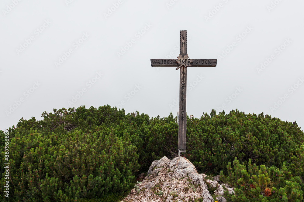 Cross on mountain top Ahornkogel in Austria alps with tree in fog Cross on mountain top Ahornkogel in Austria alps with tree in fog
