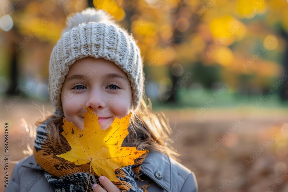 Portrait of a child girl with a smile on face holding a leaf in hand in the park Portrait of a child girl with a smile on face holding a leaf in hand in the park