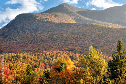 Autumn in the White Mountain National Forest of New Hampshire. Stunning view of colorful fall foliage and tall peaks of Mount Osceola from scenic overlook alongside the Kancamagus Highway. photo