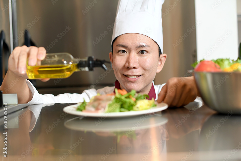 オリーブオイルをサラダにかける男性料理人 オリーブオイルをサラダにかける男性料理人