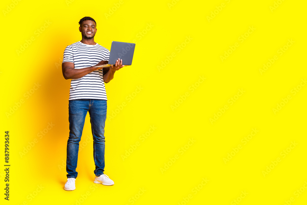 Full size photo of nice young man laptop empty space wear t-shirt isolated on bright yellow color background Full size photo of nice young man laptop empty space wear t-shirt isolated on bright yellow color background