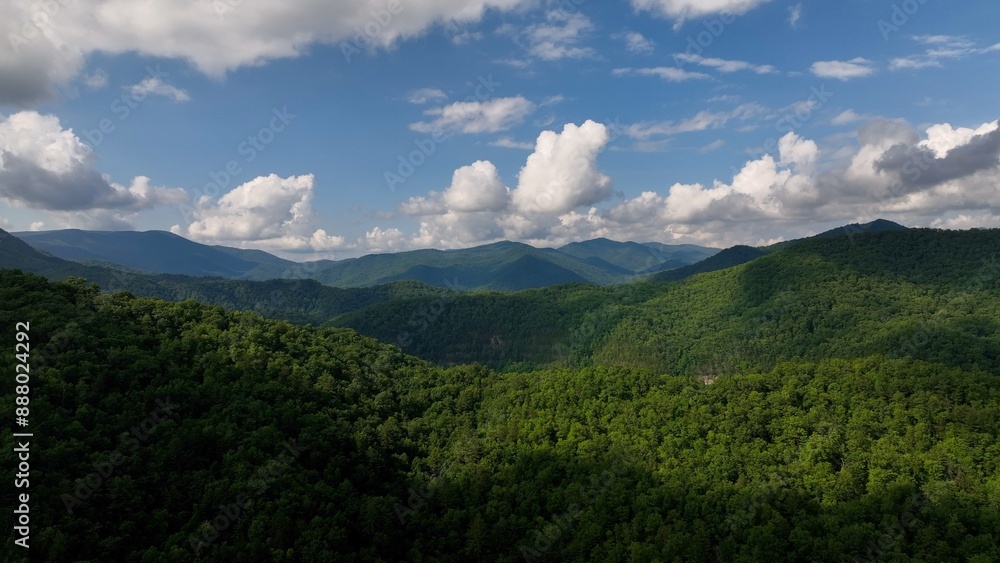 Beautiful Smoky Mountain range with green trees under blue sky and fluffy clouds Beautiful Smoky Mountain range with green trees under blue sky and fluffy clouds