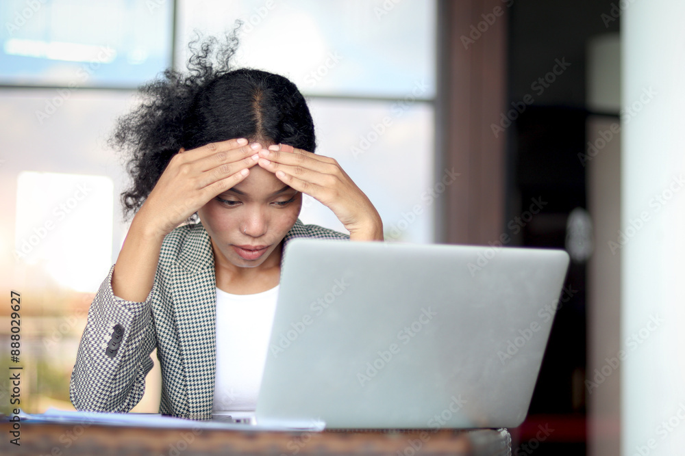 Tensed businesswoman puts head in hands in front laptop at office workplace. Woman suffers from a headache, rubs temples with fingers closing eyes in pain. Tired female officer feels stress with a job Tensed businesswoman puts head in hands in front laptop at office workplace. Woman suffers from a headache, rubs temples with fingers closing eyes in pain. Tired female officer feels stress with a job