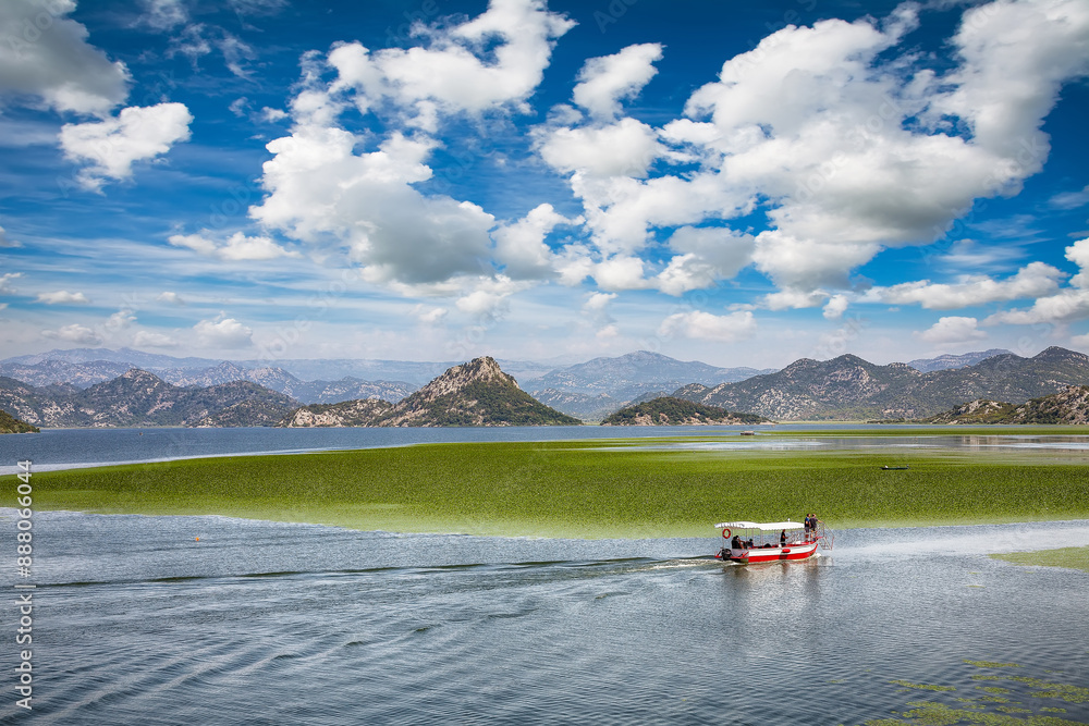 Captivating view of Skadar lake surrounded by green mountain peaks on a sunny day.