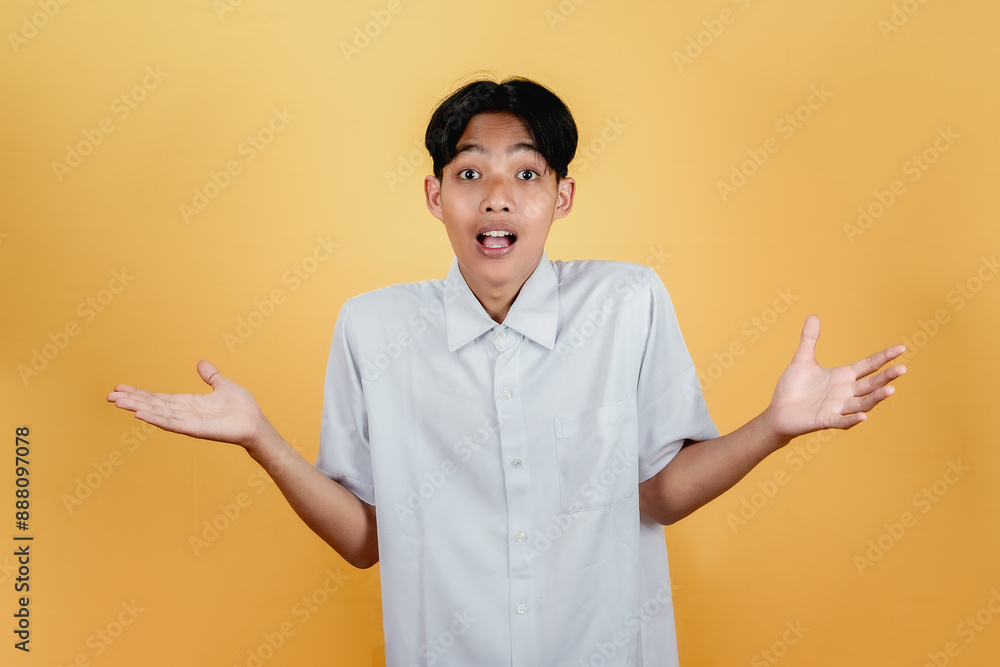 Portrait of an Asian man raised both hands, expressing that he was questioning something. Portrait of an Asian man raised both hands, expressing that he was questioning something.