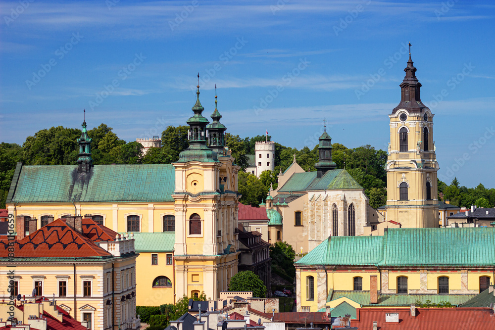 Obraz premium Top view from Clock Tower of Museum of Bells and Pipes on Cathedral of St. John the Baptist and Cathedral Basilica of Przemysl, Poland. Przemyśl Castle on the background