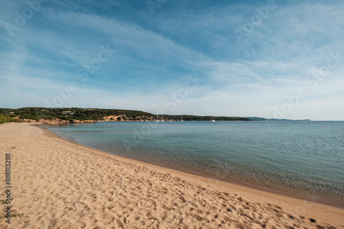 A deserted sandy beach with boats moored in the bay at Plage de Gandina near the village of Gurgazu on the south east coast of the Mediterranean island of Corsica photo