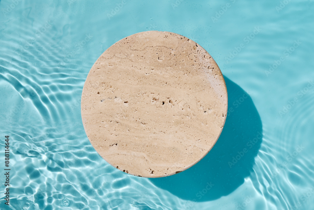 Podium for cosmetic presentation. A round stone slab floating on clear, blue water, Podium for cosmetic presentation. A round stone slab floating on clear, blue water,