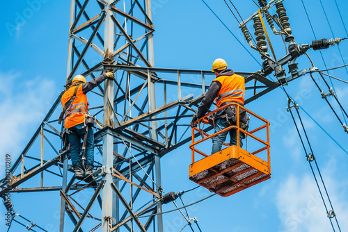 Skilled Linemen at Work on High Voltage Electricity Pylon”