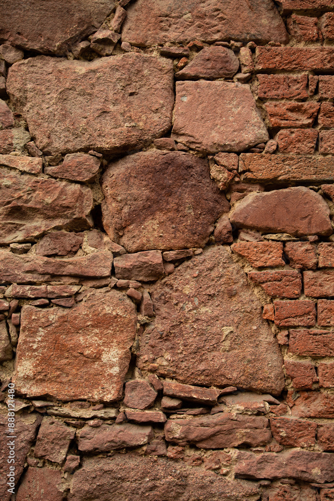 Fototapeta premium Close up. Old red wall made of various sizes stone and bricks. Background or texture. 