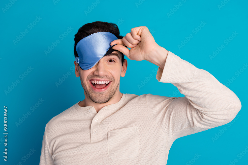 Naklejka premium Photo portrait of handsome young guy peek eyes covered mask sleep dressed sleepwear sleepover good morning isolated on blue background