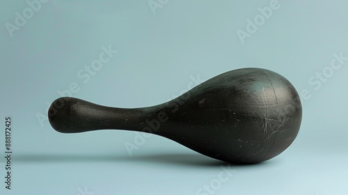 Old black Stafforshire object against pale blue backdrop in studio setting