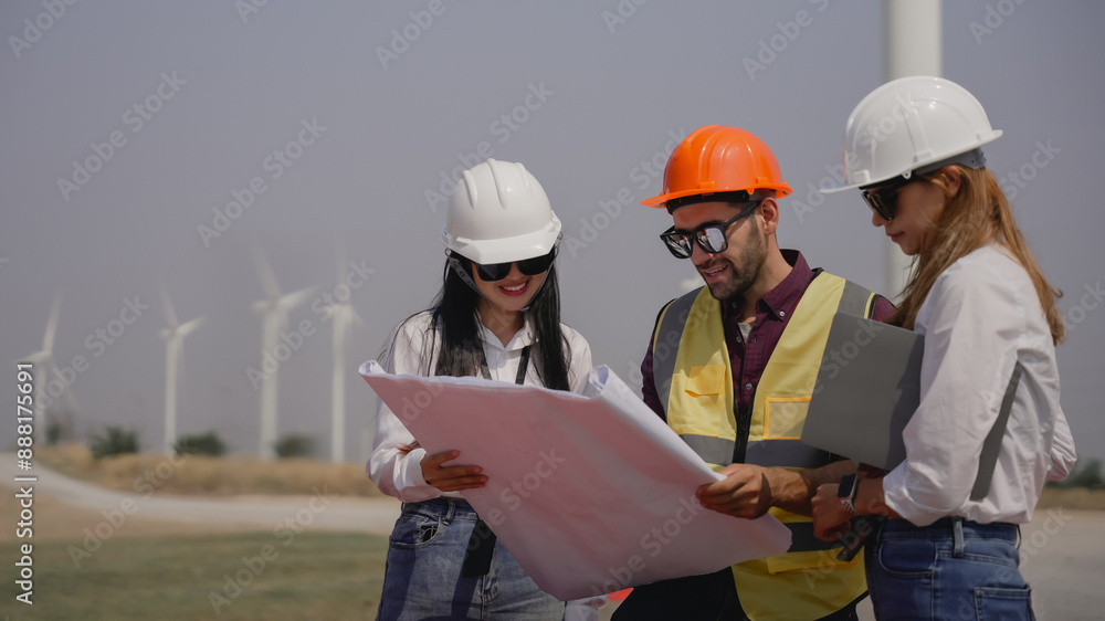 Workers talking by wind turbines in rural landscape. Technician discussing with engineers about wind turbine. Renewable energy from the wind. Workers talking by wind turbines in rural landscape. Technician discussing with engineers about wind turbine. Renewable energy from the wind.