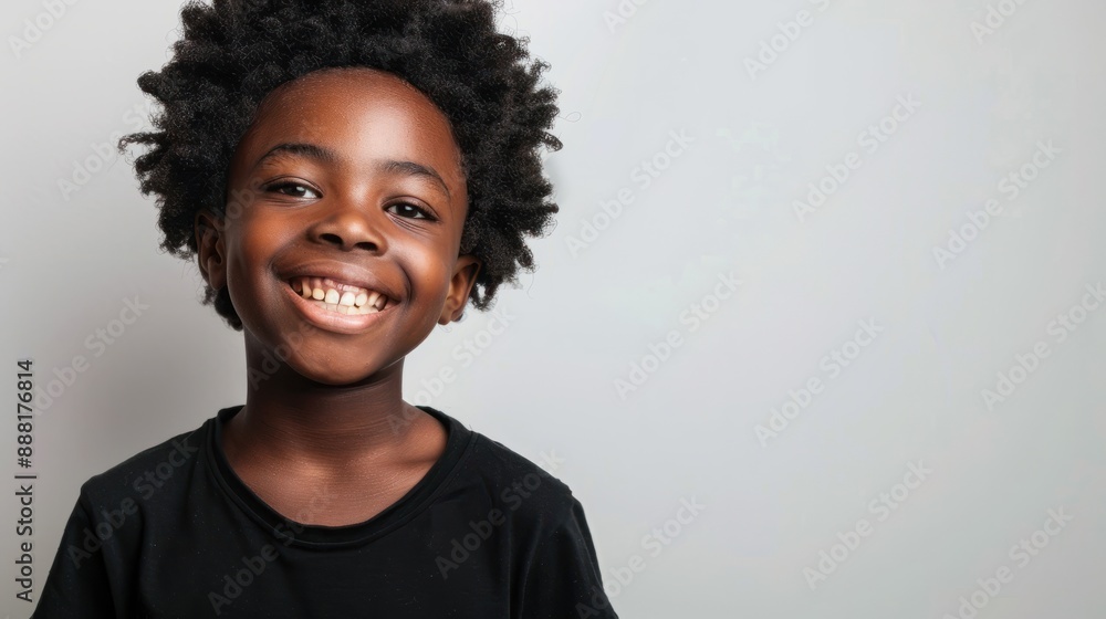 Young black boy, smiling portrait on white background, wears black t-shirt, short afro hair. Young black boy, smiling portrait on white background, wears black t-shirt, short afro hair.