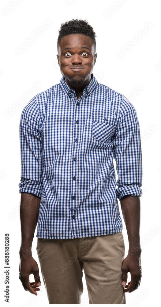 Young african american man wearing blue shirt puffing cheeks with funny face. Mouth inflated with air, crazy expression. Young african american man wearing blue shirt puffing cheeks with funny face. Mouth inflated with air, crazy expression.