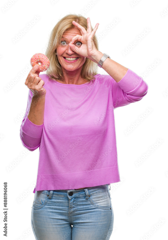 Middle age blonde woman eating pink donut over isolated background with happy face smiling doing ok sign with hand on eye looking through fingers Middle age blonde woman eating pink donut over isolated background with happy face smiling doing ok sign with hand on eye looking through fingers