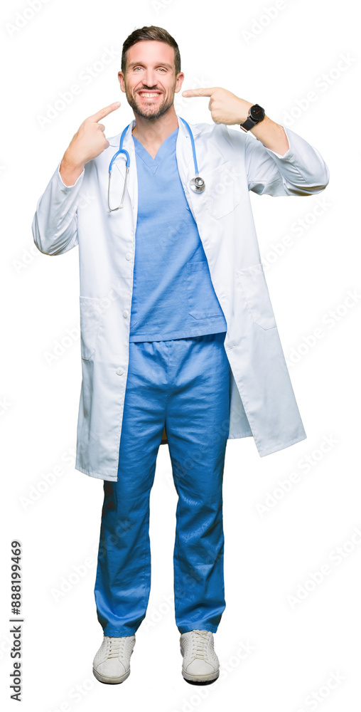 Handsome doctor man wearing medical uniform over isolated background smiling confident showing and pointing with fingers teeth and mouth. Health concept. Handsome doctor man wearing medical uniform over isolated background smiling confident showing and pointing with fingers teeth and mouth. Health concept.