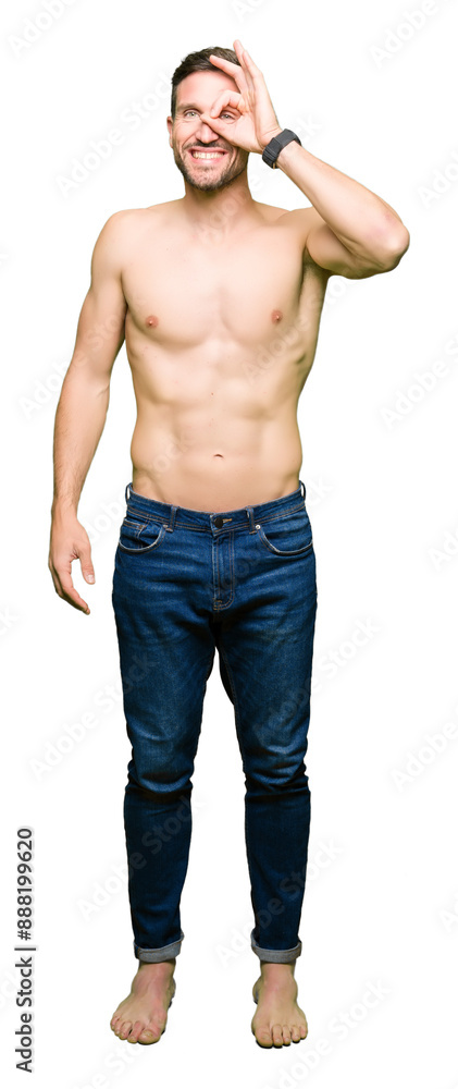 Handsome shirtless man showing nude chest doing ok gesture with hand smiling, eye looking through fingers with happy face. Handsome shirtless man showing nude chest doing ok gesture with hand smiling, eye looking through fingers with happy face.