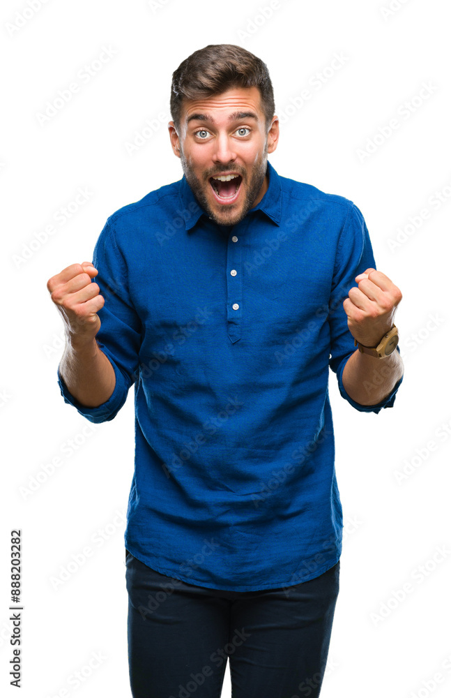 Fototapeta premium Young handsome man over isolated background celebrating surprised and amazed for success with arms raised and open eyes. Winner concept.