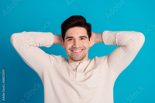 Portrait of nice young man arms behind head beaming smile wear pajama isolated on blue color background