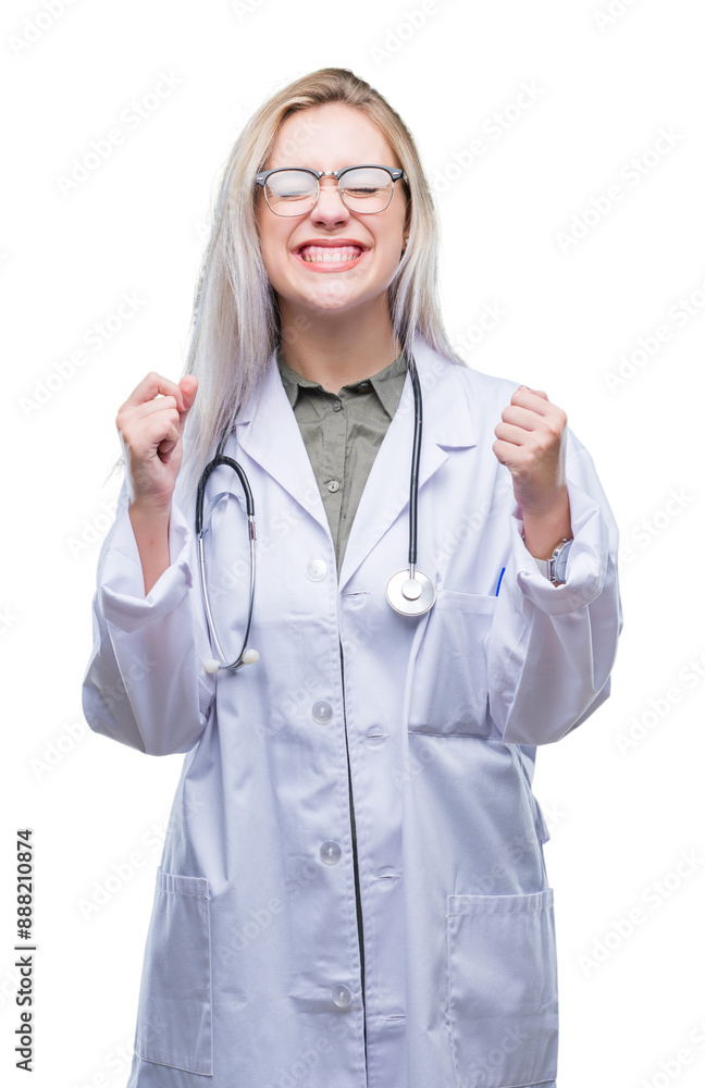 Young blonde doctor woman over isolated background excited for success with arms raised celebrating victory smiling. Winner concept. Young blonde doctor woman over isolated background excited for success with arms raised celebrating victory smiling. Winner concept.