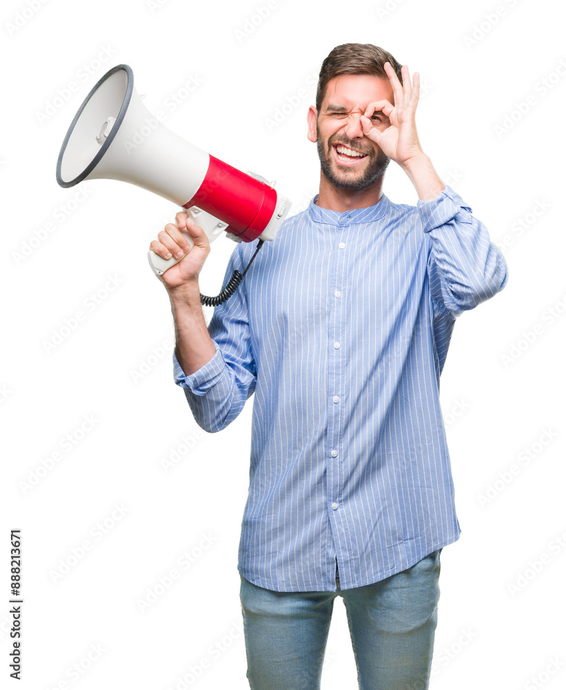 Young handsome man yelling through megaphone over isolated background with happy face smiling doing ok sign with hand on eye looking through fingers Young handsome man yelling through megaphone over isolated background with happy face smiling doing ok sign with hand on eye looking through fingers