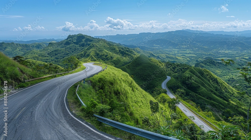 A winding mountain road cutting through lush, green hills. The road twists and turns, offering stunning views of the landscape below, with a clear blue sky overhead. A winding mountain road cutting through lush, green hills. The road twists and turns, offering stunning views of the landscape below, with a clear blue sky overhead.