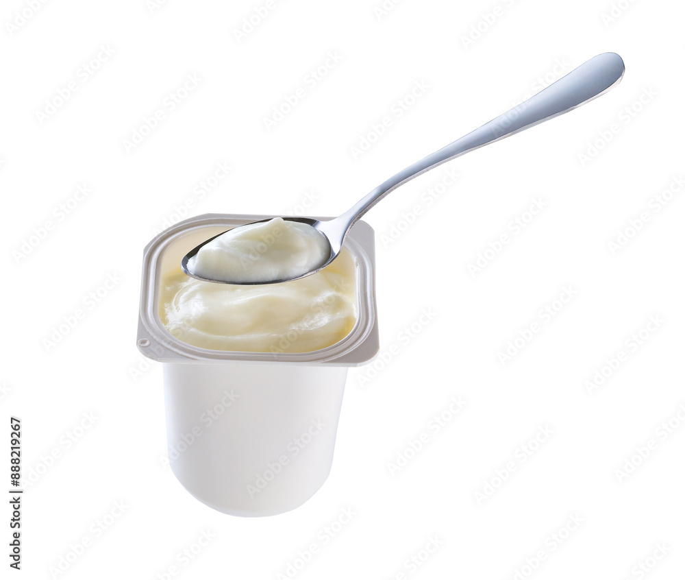 Open packing with yoghurt or tasty desser in a white plastic cup with a spoon isolated on a white background. Open packing with yoghurt or tasty desser in a white plastic cup with a spoon isolated on a white background.