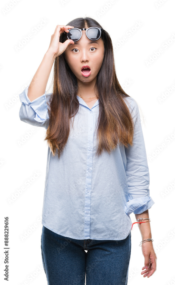 Young asian woman wearing sunglasses over isolated background afraid and shocked with surprise expression, fear and excited face. Young asian woman wearing sunglasses over isolated background afraid and shocked with surprise expression, fear and excited face.