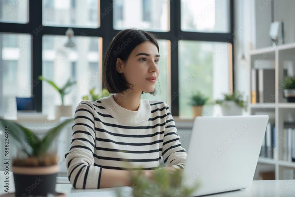 Woman working on laptop in modern office with natural light productivity concept Woman working on laptop in modern office with natural light productivity concept