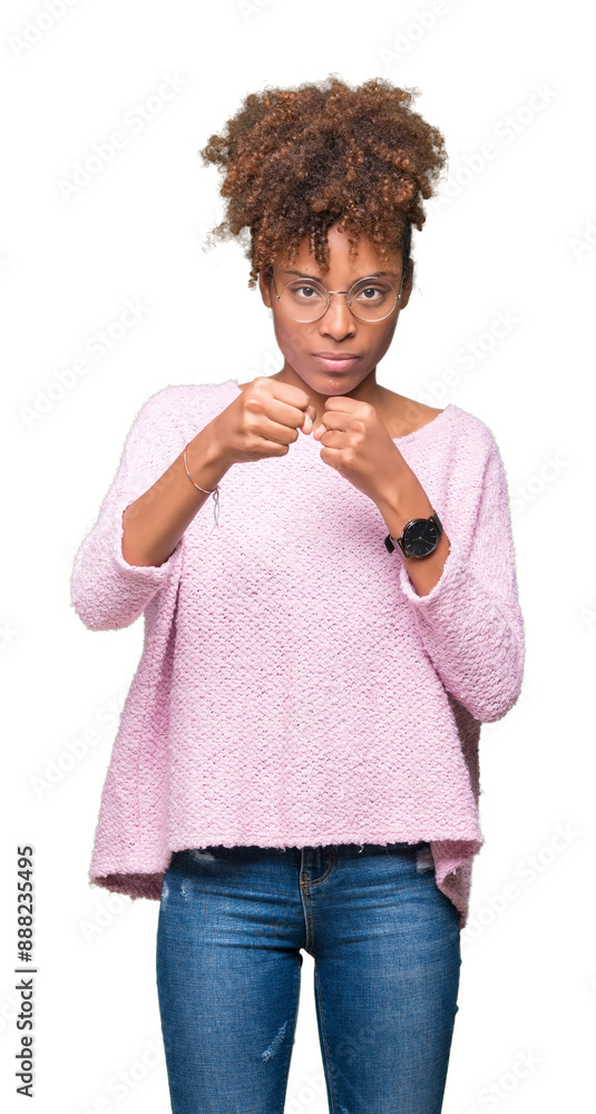 Beautiful young african american woman wearing glasses over isolated background Punching fist to fight, aggressive and angry attack, threat and violence Beautiful young african american woman wearing glasses over isolated background Punching fist to fight, aggressive and angry attack, threat and violence