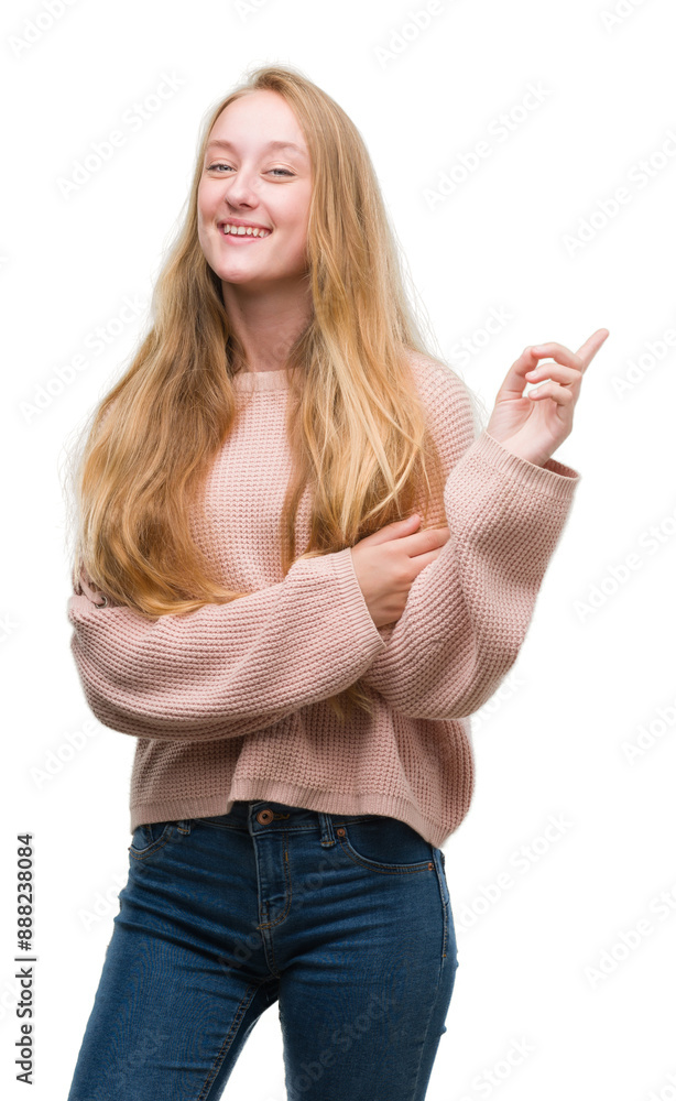 Blonde teenager woman wearing pink sweater with a big smile on face, pointing with hand and finger to the side looking at the camera. Blonde teenager woman wearing pink sweater with a big smile on face, pointing with hand and finger to the side looking at the camera.