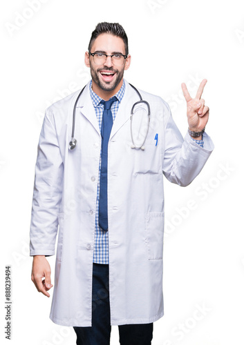 Handsome young doctor man over isolated background smiling with happy face winking at the camera doing victory sign. Number two.