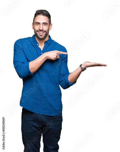 Young handsome man over isolated background amazed and smiling to the camera while presenting with hand and pointing with finger.