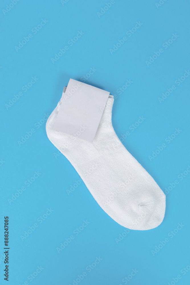 Pair of white socks with blank labels on blue background. Mock up with blank label Pair of white socks with blank labels on blue background. Mock up with blank label