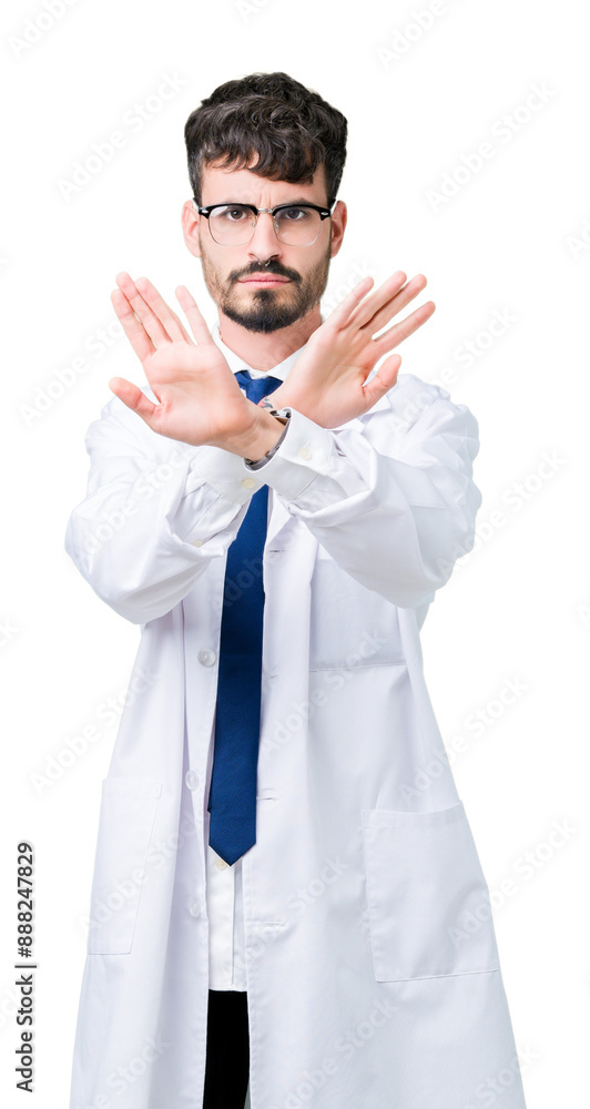 Young professional scientist man wearing white coat over isolated background Rejection expression crossing arms and palms doing negative sign, angry face Young professional scientist man wearing white coat over isolated background Rejection expression crossing arms and palms doing negative sign, angry face
