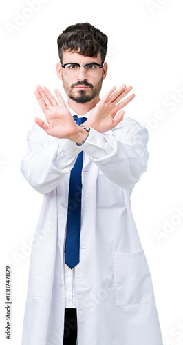 Young professional scientist man wearing white coat over isolated background Rejection expression crossing arms and palms doing negative sign, angry face